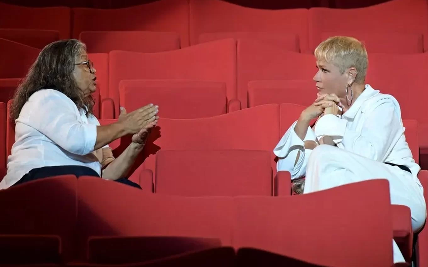 Xuxa e Marlene Mattos conversam em auditório vazio em cena do documentário