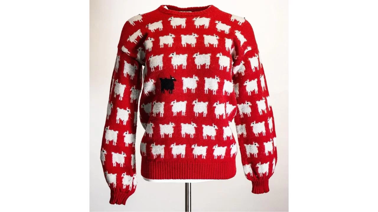 Suéter vermelho em tricô com ovelhas brancas e uma preta bordadas