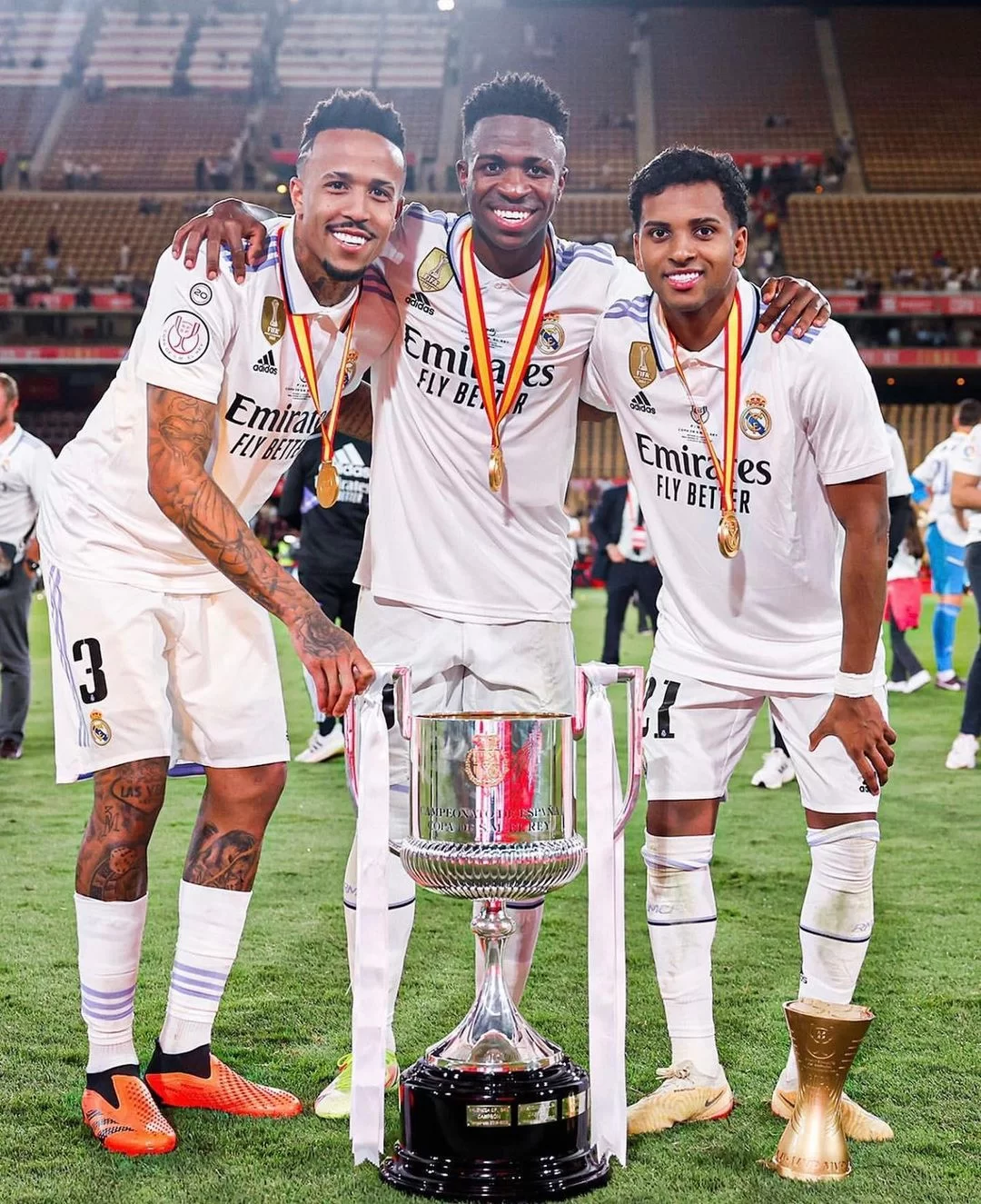 Vini, Éder Militão e Rodrygo posam para foto em título conquistado. 