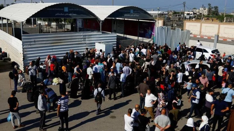 Palestinos se reúnem na passagem de fronteira de Rafah com o Egito.