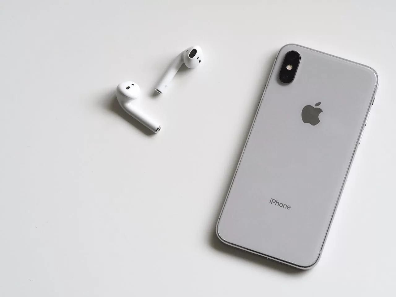 iPhone com fones de ouvidos em mesa