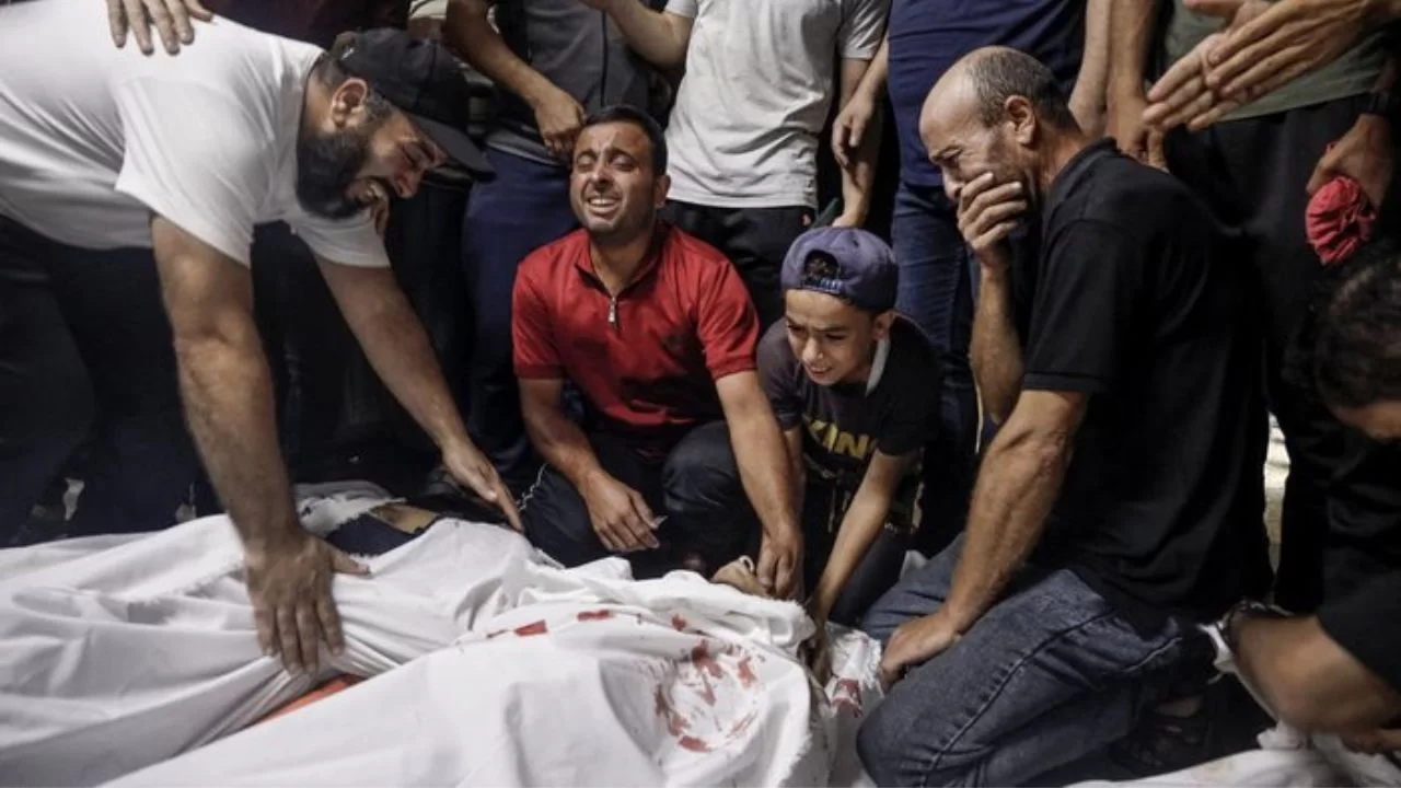 Familiares choram sobre os corpos de militantes palestinos mortos durante operação de infiltração em Israel. 