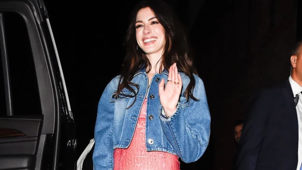 Anne Hathaway combina jaqueta jeans e vestido social em ato de versatilidade Lorena Bueri