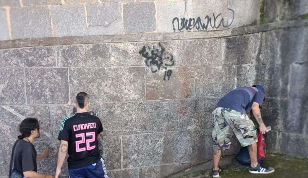 Colombianos limpam muro do Cristo Redentor, após prisão por picharem o monumento