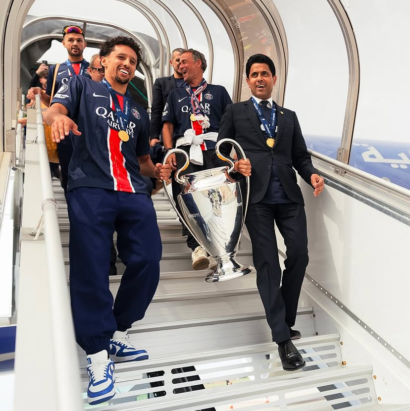 Jogadores e equipe do PSG chegando ao aeroporto com o troféu do Mundial de Clubes. 